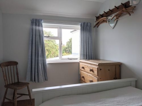 Second bedroom with wide pine floors, overlooking the back garden